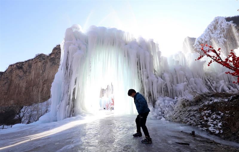 12月16日，在河北省平山县沕沕水景区，一个小朋友在冰瀑群中游玩。