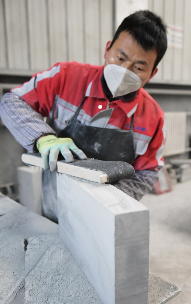 12月16日，在甘肃省临夏回族自治州临夏县一砖雕公司，工作人员在打磨青砖。