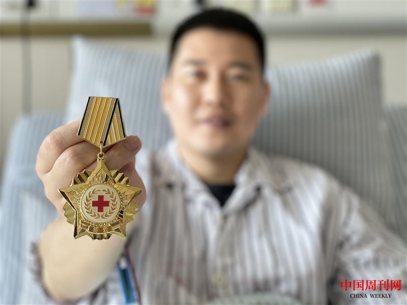 华国良展示博爱勋章.jpg