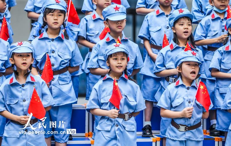 5月31日，南宁市滨湖路小学长虹校区的学生们挥舞国旗，唱响红色歌曲。