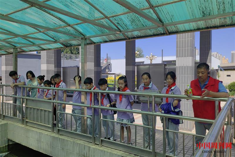 4、桥西污水处理厂的工作人员为队员们介绍污水沉淀池。 魏树霞 摄.jpg